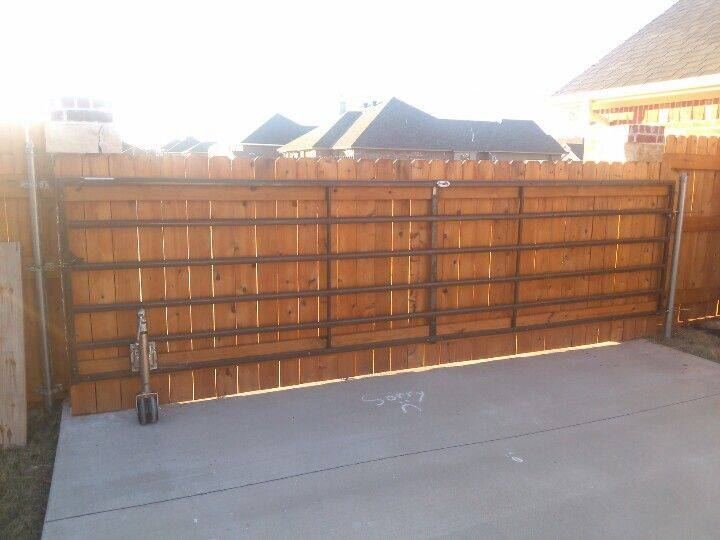 Wood driveway gate installed on a concrete drive